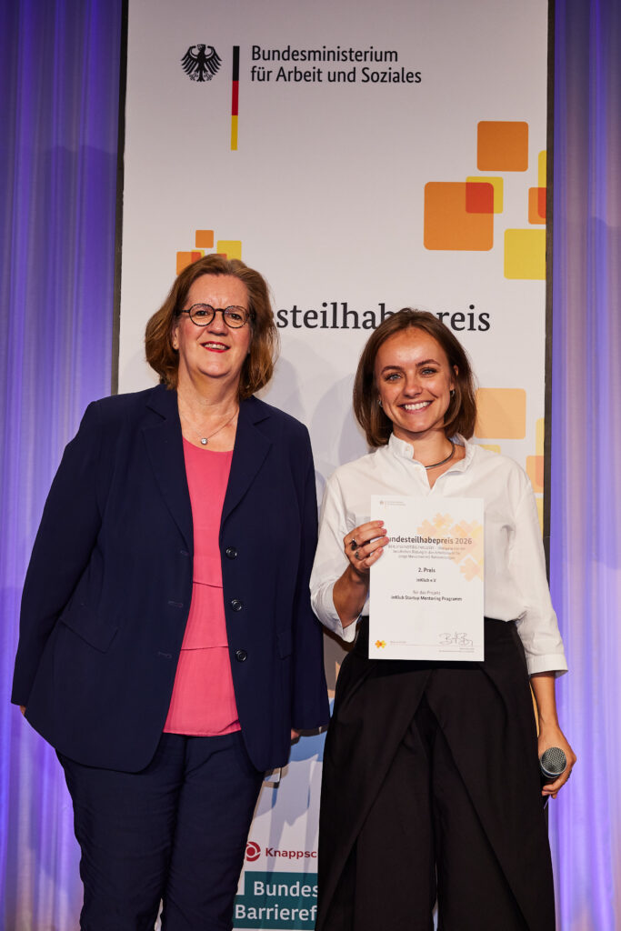 Auf dem Bild sieht man Sophie Dienberg (die Gründerin von inKlub) der von Kerstin Griese (Parlamentarische Staatssekretärin bei der Bundesministerin für Arbeit und Soziales) der Bundesteilhabepreis überreicht wird.